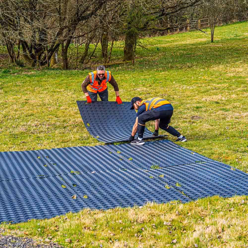 Two person manual handling of ground protection mat using handholds